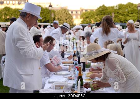 Treffen von Menschen in Weiß gekleidet für das 30. Diner en Blanc (Dinner in Weiß) auf der Invalides Esplanade in Paris, Frankreich am 3. Juni 2018. Das Diner en Blanc ist ein schickes heimliches Flashmob-Picknick, das jedes Jahr in über zwanzig Städten auf der ganzen Welt stattfindet und wo Gäste in weiß gekleidet anwesend sein müssen und ihre eigenen Stühle, Tische, Besteck sowie ihr Essen und Trinken mitbringen müssen. Foto von Aurore Marechal/ABACAPRESS.COM Stockfoto