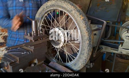 November 2020- Mahroli, Jaipur, Indien / Nahaufnahme des Fahrradreifens, Montage auf Drehmaschine für die Reparatur. Stockfoto