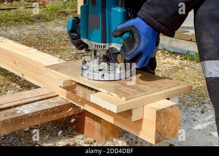 Der Prozess der Holzbearbeitung mit einer Rundmaschine. Leidenschaft für Holzschnitzerei. Goldene Hand. Stockfoto