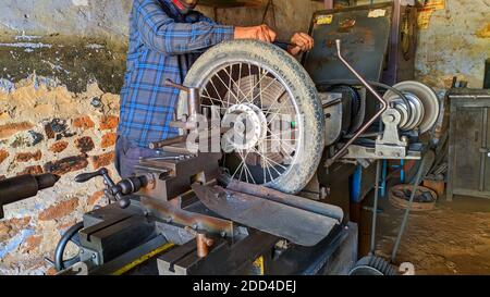 November 2020- Mahroli, Jaipur, Indien / Nahaufnahme des Fahrradreifens, Montage auf Drehmaschine für die Reparatur. Stockfoto