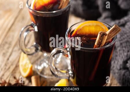 Traditioneller Glühwein mit Gewürzen auf Holztisch Stockfoto