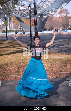 Eine paraguayische amerikanische Tänzerin probt im Flushing Meadows Corona Park und balanciert dabei 3 Weinflaschen auf ihrem Kopf. Stockfoto