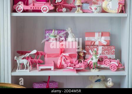 Weihnachtsgeschenke in Box auf ein Regal, rosa Auto, Flugzeug, Holzpferd und Gingle Bell. Stockfoto