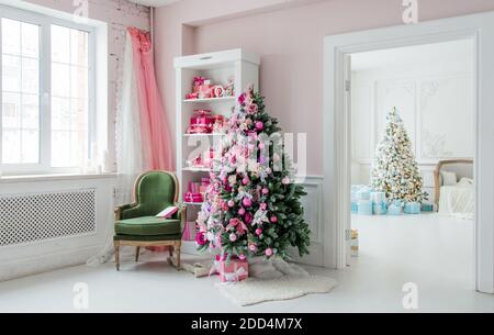 Schöne Ferienwohnung eingerichtete Zimmer mit Weihnachten Bäume, Regal und rosa blau Geschenke drauf, grünen Stuhl Wohngebäude Stockfoto