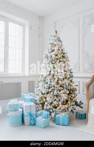 Weihnachtsbaum Dekoration am Wohngebäude mit blauen Geschenkboxen Stockfoto