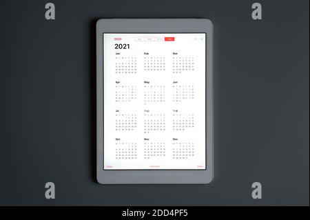 Ein Tablet mit offenem Kalender für 2021 Jahre Ein dunkelgrauer Hintergrund Stockfoto