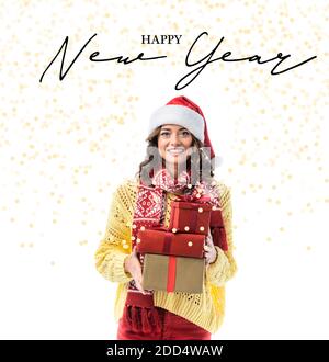 Fröhliche junge Frau in santa Hut und Schal mit Geschenken Fast frohes neues Jahr Schriftzug auf weiß Stockfoto