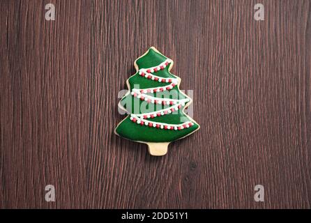 Draufsicht auf dekorierte grüne Ebene Geschmack Lebkuchen Weihnachtsbaum Cookie auf Holztisch Hintergrund mit Kopieplatz, Konzept der Feiertagsfeier. Stockfoto