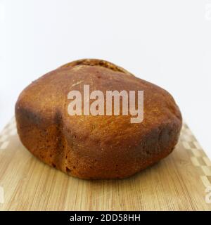 Hausgemachtes Vollkorn Roggen Weizen Sauerteig Bio Brot Laib auf Holzbrett auf weißem Hintergrund Stockfoto