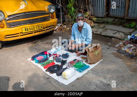 Ein undefinierter Mann, der am 2020. Oktober in Kalkutta, Westbengalen, Indien, Masken neben der Straße verkauft Stockfoto