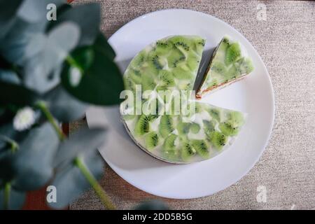 Roher veganer grüner Kiwi-Kuchen mit Scheiben verziert. Kokosnuss Chia Füllung Gelee vegetarisch Cashew Sahne Käsekuchen glutenfrei. Laktosezucker freier Urlaub Stockfoto