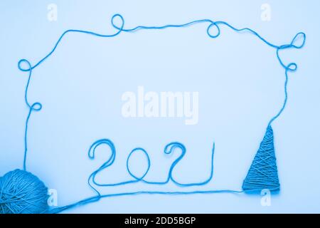 Ball aus blauen Fäden und die Inschrift 2021 gemacht mit Fäden auf hellblauem Hintergrund Stockfoto