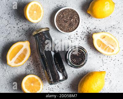 Detox Aktivkohle schwarz Chia Wasser oder Limonade mit Zitrone. Zwei Flaschen Wasser mit schwarzen Chia infundiert. Detox drink Idee und Rezept. Veganes Essen und Trinken. Ansicht von oben. Stockfoto