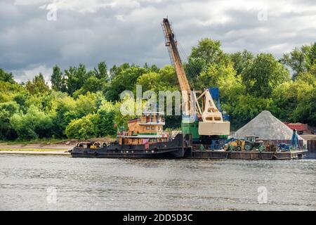 Kran und Lastkahn für Sand am Ufer der Wolga Im Frühling wolkiger Tag Stockfoto