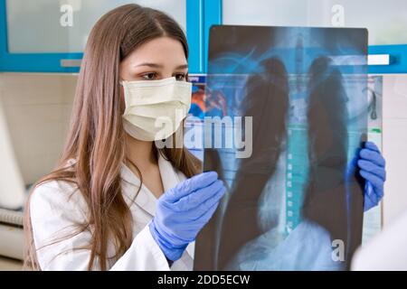 Ärztin im Krankenhaus betrachtet die Röntgenaufnahme der Lunge. Stockfoto