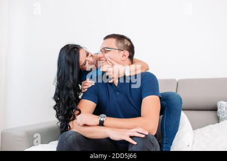 Junges Paar, das liebevoll miteinander ist. Frau umarmte ihren Mann von hinten Stockfoto