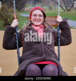 Frau schwingt auf einer Schaukel im Herbstpark Stockfoto