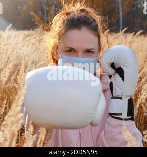 Boxerin geht in Sport auf dem Hintergrund der herbstlichen Natur. Sonniger Sonnenuntergang im Herbstpark Stockfoto