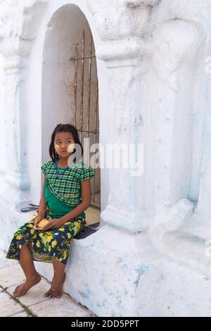 Mädchen mit thanaka an den Backen halten Topf von thanaka zu bieten und für die Besucher in der Kuthodaw Pagode, Mandalay, Myanmar (Birma), Asien im Februar gelten Stockfoto