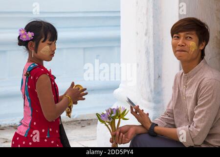 Mädchen Anwendung thanaka auf die Wange des Mannes in der Kuthodaw Pagode, Mandalay, Myanmar (Birma), Asien im Februar Stockfoto