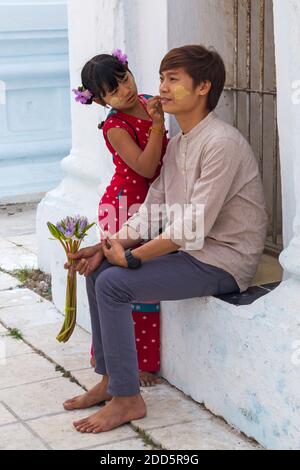 Mädchen Anwendung thanaka auf die Wange des Mannes in der Kuthodaw Pagode, Mandalay, Myanmar (Birma), Asien im Februar Stockfoto