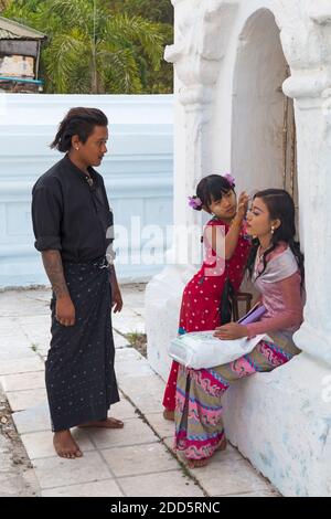 Mädchen Anwendung thanaka auf die Wange der Dame an der Kuthodaw Pagode, Mandalay, Myanmar (Birma), Asien im Februar Stockfoto