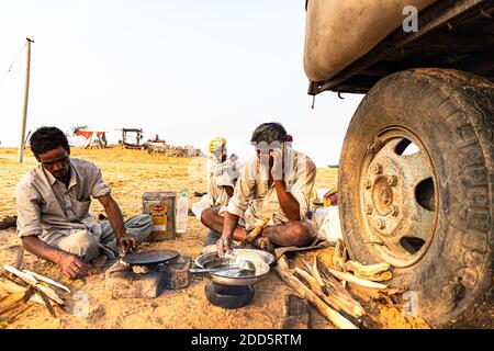 Nomadic rajasthani Mann macht Essen in der offenen Küche. Stockfoto