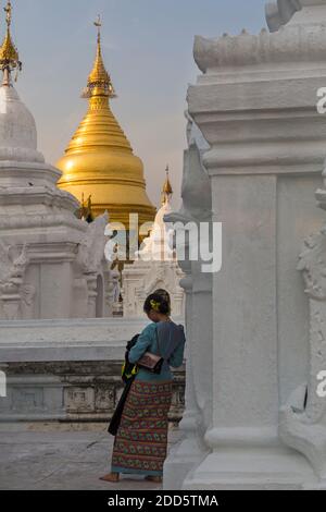 Junge Frau, die im Februar in der Kuthodaw Pagode, Mandalay, Myanmar (Burma), Asien steht - Rückansicht von hinten Stockfoto