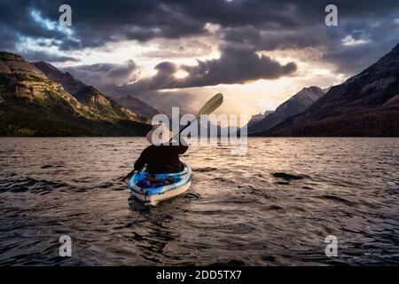 Abenteuerlicher Mann Kajakfahren in Glacier Lake Stockfoto