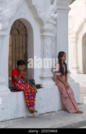 Junge Mädchen, die im Februar in der Kuthodaw Pagode, Mandalay, Myanmar (Burma), Asien sitzen Stockfoto
