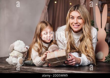 Glückliche Mutter und kleine Tochter Eröffnung Weihnachtsgeschenke zu Hause Stockfoto