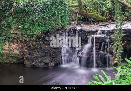 Wasser fließt über historische verlassene Bauernhof Wassermühle Bau Stockfoto