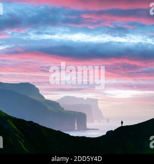 Mann Silhouette am Hintergrund des berühmten risin und Kellingin Felsen und Klippen von Eysturoy und Streymoy Inseln von kalsoy Insel gesehen. Färöer, Dänemark. Landschaftsfotografie Stockfoto
