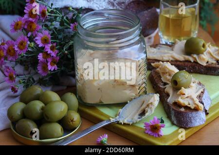 Brunost Käse mit schwarzem Brot und Oliven Stockfoto