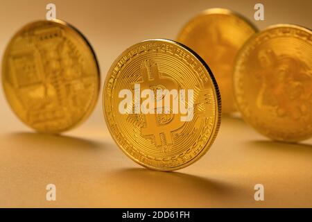 Nahaufnahme von Goldbitcoin-Münzen, die auf gelbem Hintergrund stehen Stockfoto