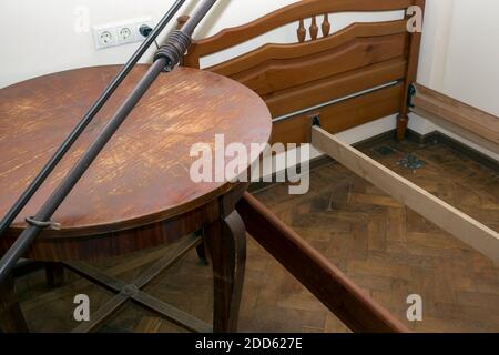 Alter Holztisch und zerlegtes Holzbett, Innenaufnahme Stockfoto
