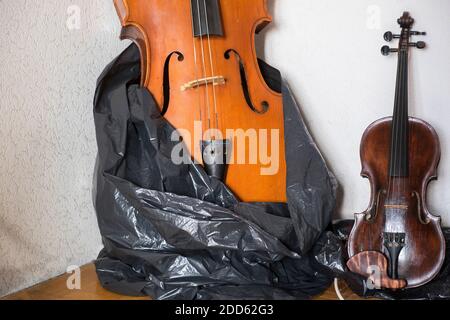 Cello und Violine müssen scheinbar repar und in A platziert Zimmerecke Stockfoto