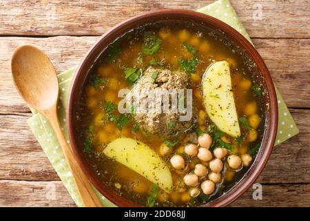 Aserbaidschanische Suppe aus Lammfleischbällchen Kichererbsen und Kartoffeln aus der Nähe in einem Teller auf dem Tisch. Horizontale Ansicht von oben Stockfoto