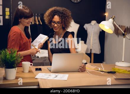 Zwei junge Unternehmerinnen und Modedesigner, die am Atelier arbeiten Stockfoto