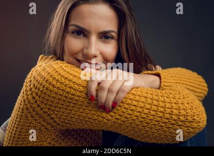 Aufnahme einer schönen jungen Frau, die zur Kamera schaut und lächelt Stockfoto