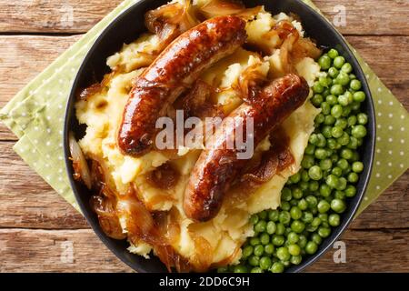 Irish Bangers and Mash ist ein Gericht, bestehend aus Würstchen mit Kartoffelpüree und Zwiebelsoße in der Nähe in der Platte auf dem Tisch serviert. Horizontal oben Stockfoto