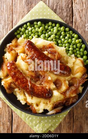 Knaller und Maische mit Zwiebelsoße Nahaufnahme in den Teller auf dem Tisch. Vertikale Draufsicht von oben Stockfoto