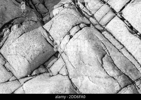 Ein Becken, ein Pool in den Mulden von glatten Granitsteinen. Kolonien von Muscheln und Krebstieren. Natürlicher Hintergrund. Atlantikküste in Porto, Portuga Stockfoto