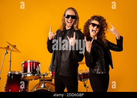 Portrait von lustigen zwei Menschen Freundin Freund Rock-Band-Team Genießen Sie Party Punk Event-Show gehörnte Symbol tragen schwarzes Leder Sonnenschutzhülle isoliert Stockfoto