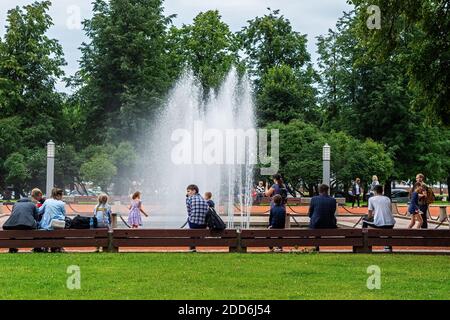 Sankt Petersburg, Russland, 3. August: Touristen und Stadtbewohner ruhen an einem warmen Sommertag in St. Petersburg, August, in der Nähe des Brunnens auf dem Stadtplatz Stockfoto