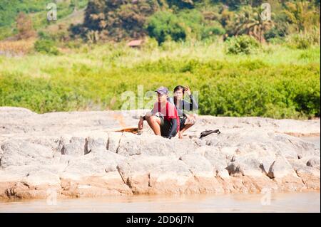 Thailänder machen Feuer am Ufer des Mekong vom Slow Boat aus Thailand nach Vientiane, Laos, Südostasien Stockfoto