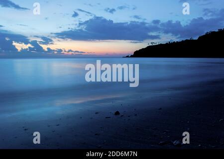 Langzeitbelichtung von Wellen und den kühlen blauen Farben des Sonnenuntergangs am Nippah Beach, Lombok, West Nusa Tenggara, Indonesien, Asien, Hintergrund mit Kopierraum Stockfoto