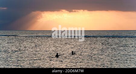 Fischer Angeln bei Sonnenuntergang im Meer am Sengiggi Strand, gegen die Sonne silhouetted, Lombok, Indonesien, Asien Stockfoto