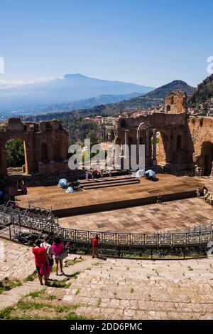 Teatro Greco aka Taormina Griechisches Theater, Touristen Sightseeing im Amphitheater mit Vulkan Ätna hinter, Sizilien, Italien, Europa Stockfoto