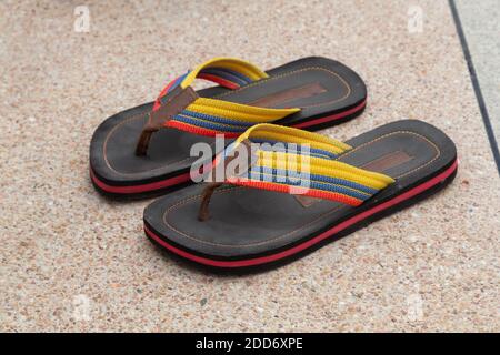 Nahaufnahme von Paar Stoff-und Gummi-Sandalen mit verschiedenen Farben, auf dem Boden, lässigen Stil Stockfoto